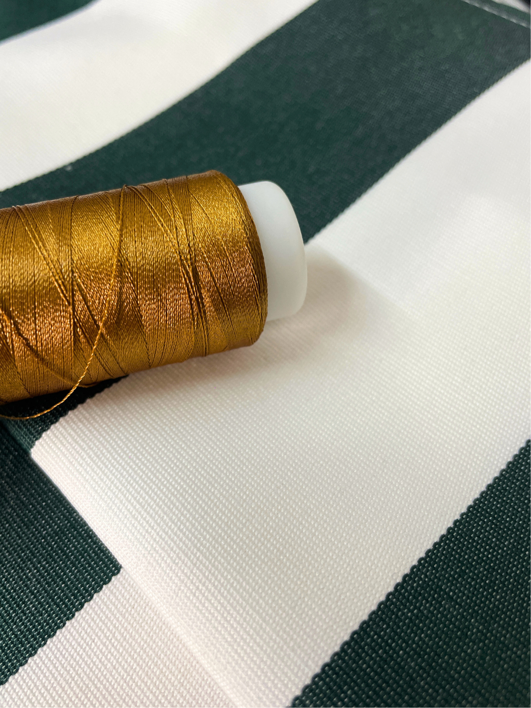 Heavy, off-white premium canvas fabric tightly stretched with delicate gold embroidery.